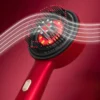 Scalp massage brush emitting red light therapy during use